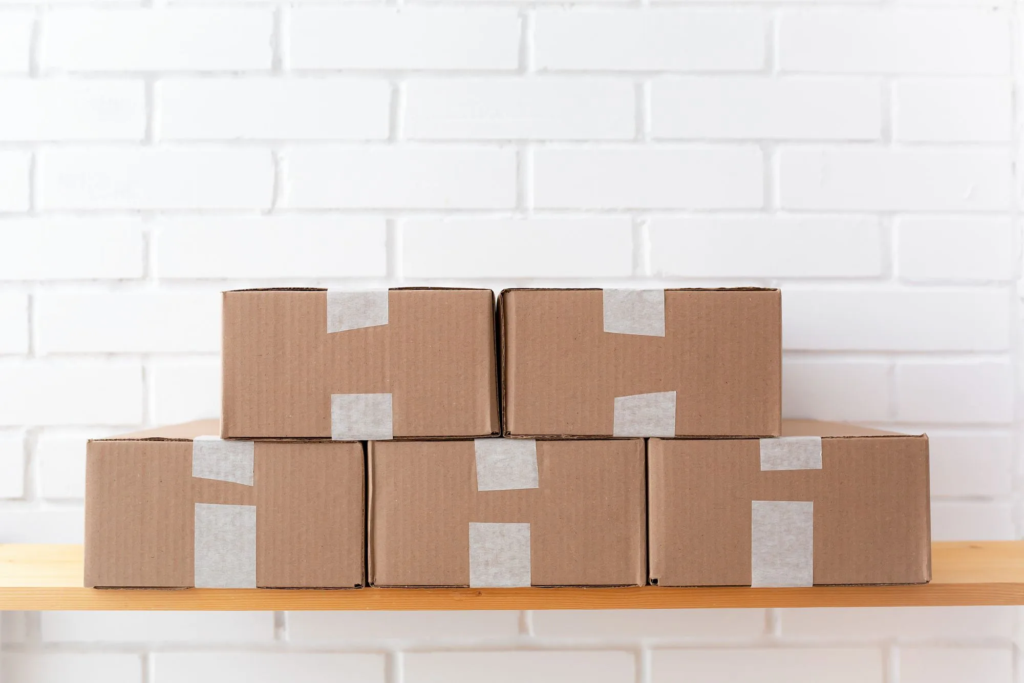 Cartons sealed with paper-based tape on a warehouse shelf